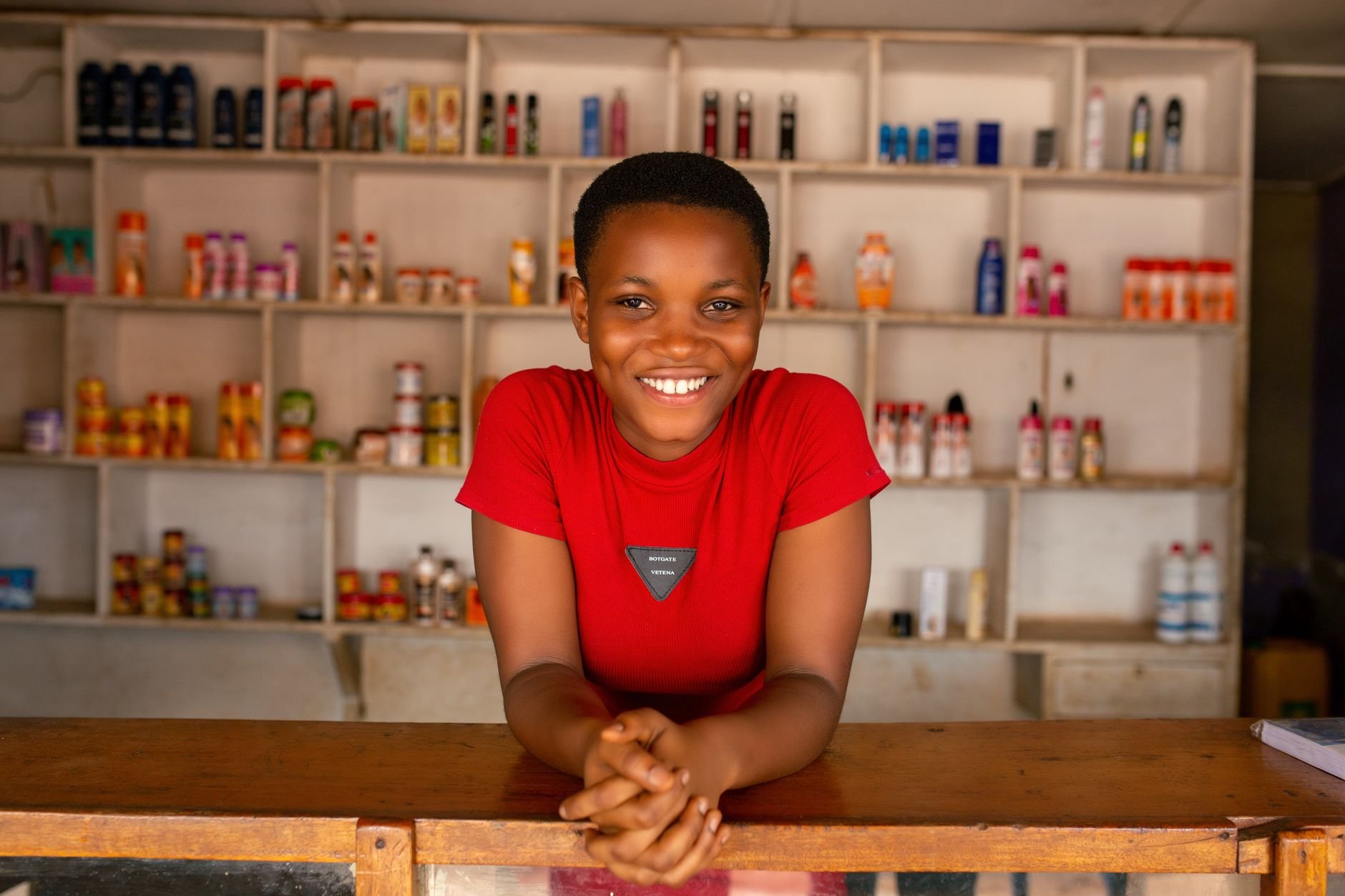 A cheerful business owner behind her store counter, ready to grow.